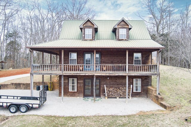 view of front of house featuring metal roof and a patio