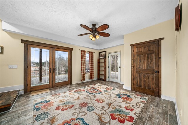 foyer with a textured ceiling, wood finished floors, and french doors