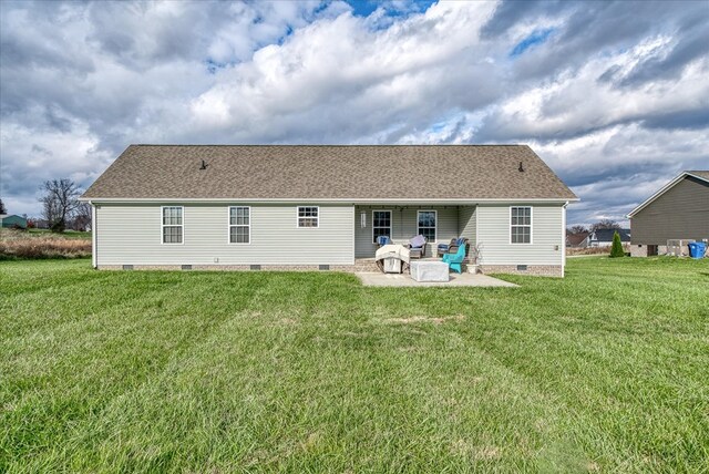 rear view of house with a patio, roof with shingles, crawl space, and a lawn