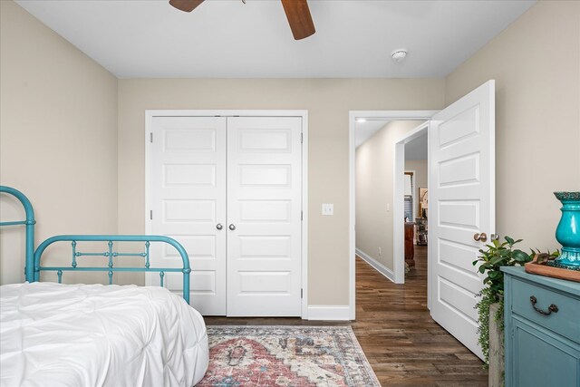 bedroom with dark wood-style floors, a closet, a ceiling fan, and baseboards