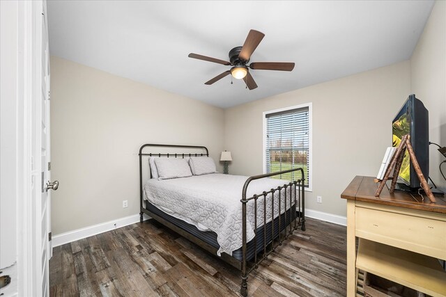 bedroom with a ceiling fan, dark wood-style flooring, and baseboards