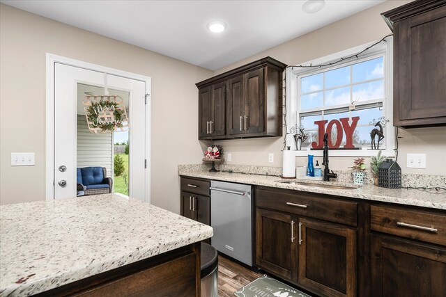 kitchen featuring dark wood finished floors, light stone counters, dark brown cabinets, and a sink