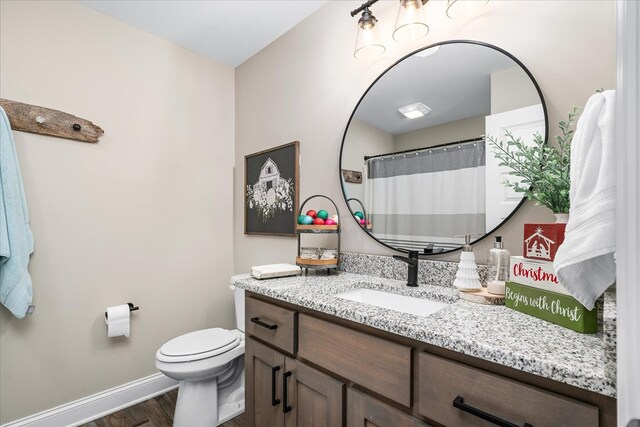 full bathroom featuring baseboards, vanity, toilet, and wood finished floors