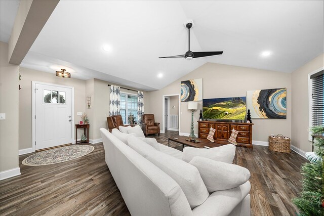 living room featuring dark wood-style floors, vaulted ceiling, baseboards, and a ceiling fan