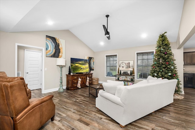 living area with vaulted ceiling, wood finished floors, and baseboards