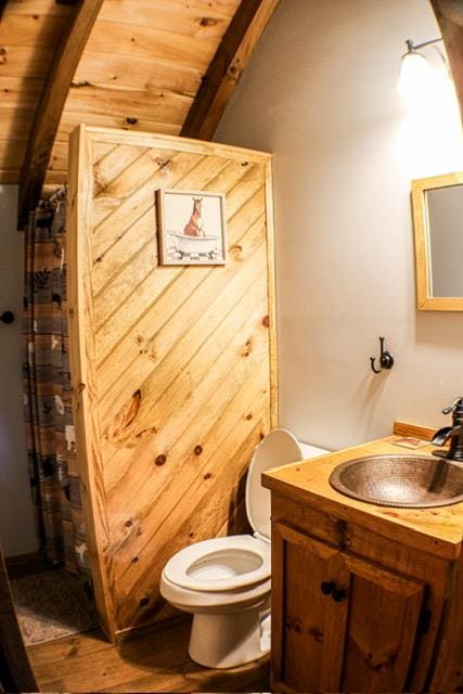 full bath featuring wooden ceiling, toilet, wood finished floors, vanity, and vaulted ceiling