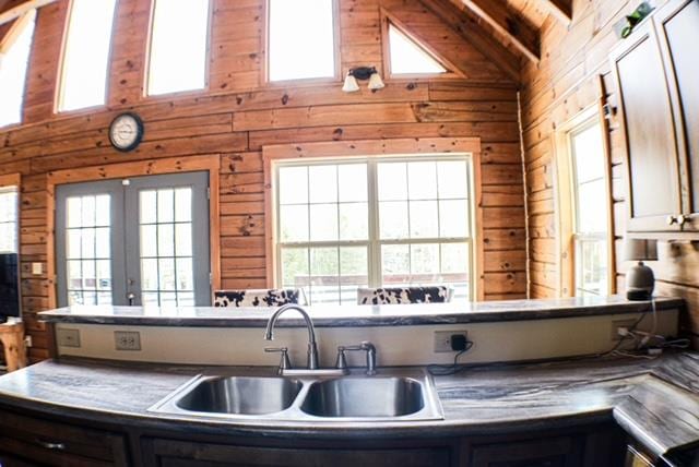 kitchen with plenty of natural light, a sink, and wood walls