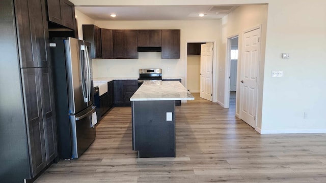 357 Taylor Rd, Byrdstown, TN 38549 - kitchen with appliances with stainless steel finishes, under cabinet range hood, light wood-type flooring, light countertops, and dark brown cabinets