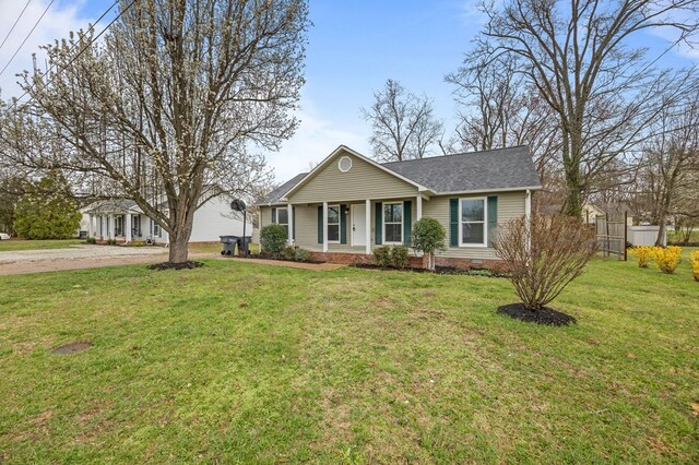 view of front of property featuring driveway, a front lawn, fence, roof with shingles, and crawl space
