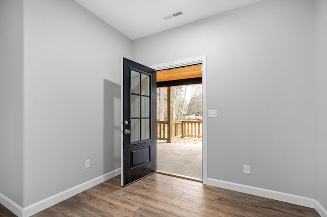 interior space with wood finished floors, visible vents, and baseboards