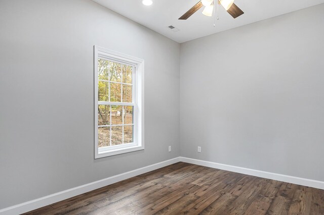 spare room with dark wood-style flooring, ceiling fan, and baseboards