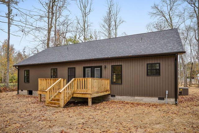 rear view of property with crawl space, a shingled roof, cooling unit, and a wooden deck