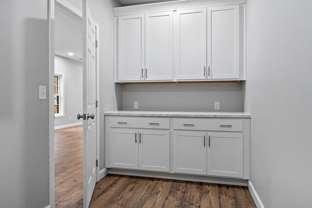 kitchen featuring light countertops, dark wood-style flooring, white cabinetry, and baseboards