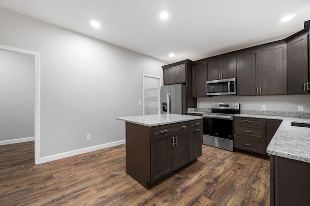 kitchen with dark wood finished floors, stainless steel appliances, dark brown cabinets, and a center island