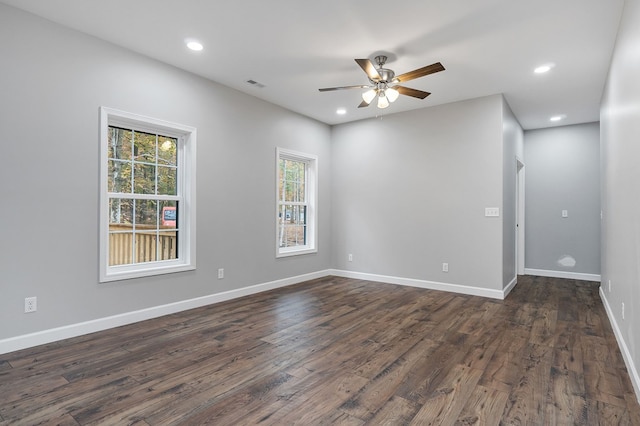 unfurnished room featuring baseboards, visible vents, dark wood-style flooring, and recessed lighting