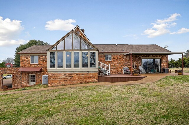 back of house with a yard and brick siding