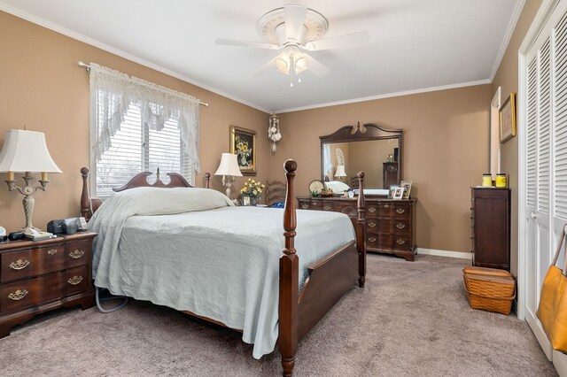 bedroom with ornamental molding, a closet, light colored carpet, and ceiling fan