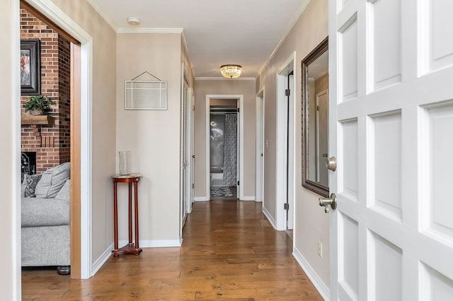 corridor featuring dark wood finished floors, crown molding, and baseboards