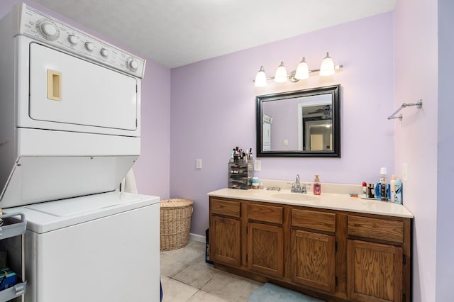 bathroom featuring tile patterned floors, vanity, and stacked washer / drying machine