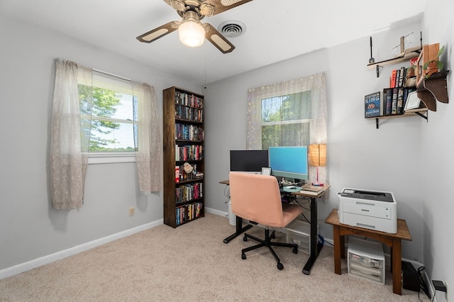 office area with light colored carpet, visible vents, ceiling fan, and baseboards