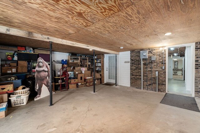 finished basement with brick wall and wooden ceiling