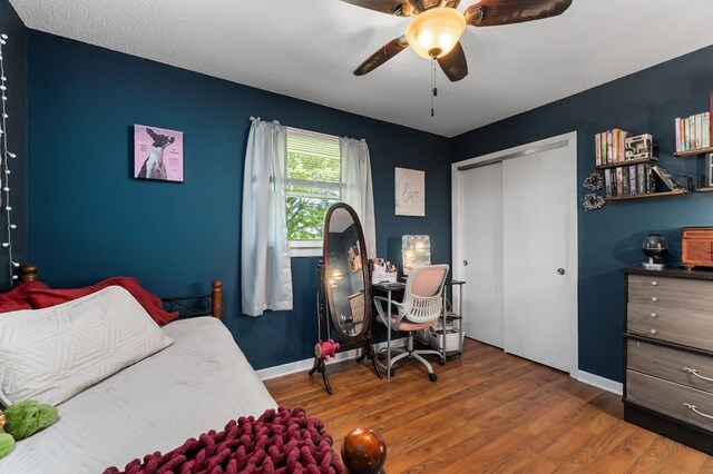 bedroom with baseboards, a closet, a ceiling fan, and wood finished floors