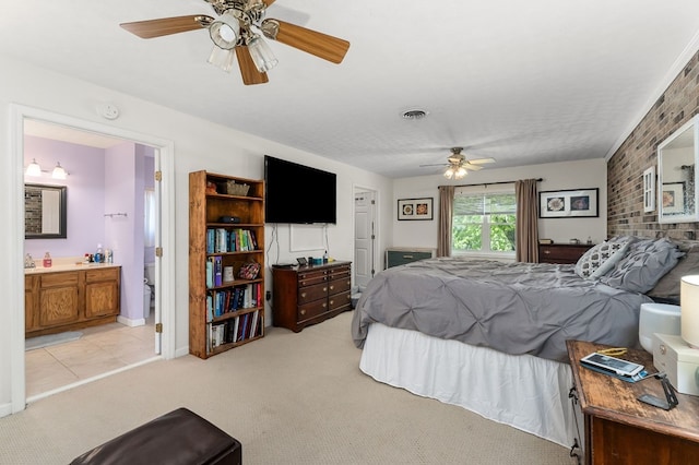 bedroom featuring light carpet, visible vents, connected bathroom, brick wall, and ceiling fan