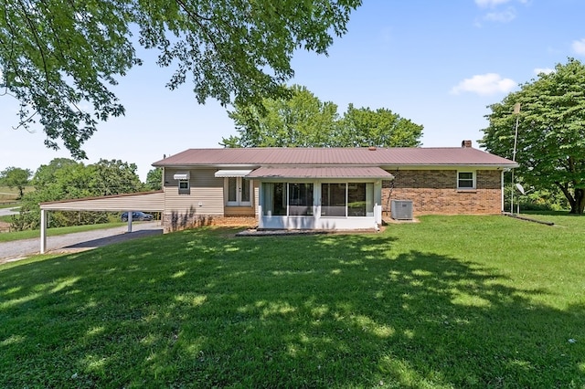 ranch-style house with brick siding, a chimney, a front lawn, and central air condition unit