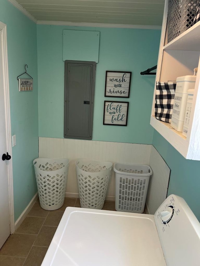 clothes washing area with electric panel, a wainscoted wall, laundry area, and crown molding