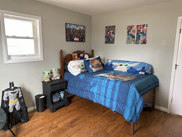 bedroom featuring baseboards and wood finished floors