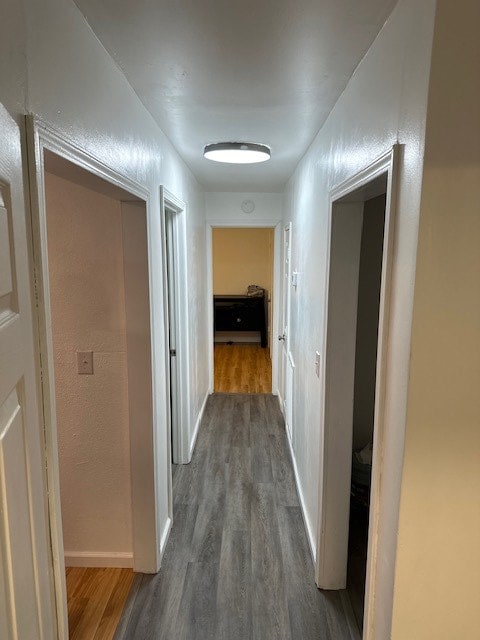 hall featuring baseboards and dark wood finished floors