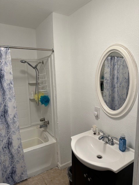 bathroom featuring a textured wall, tile patterned flooring, vanity, and shower / bathtub combination with curtain