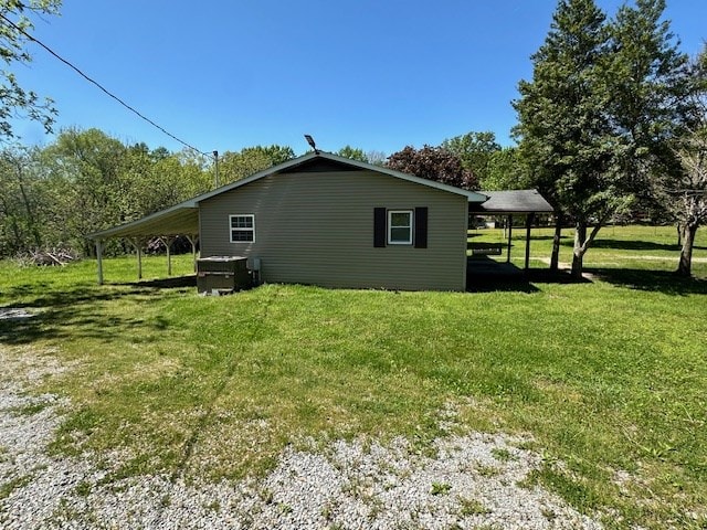 view of home's exterior featuring an attached carport and a lawn