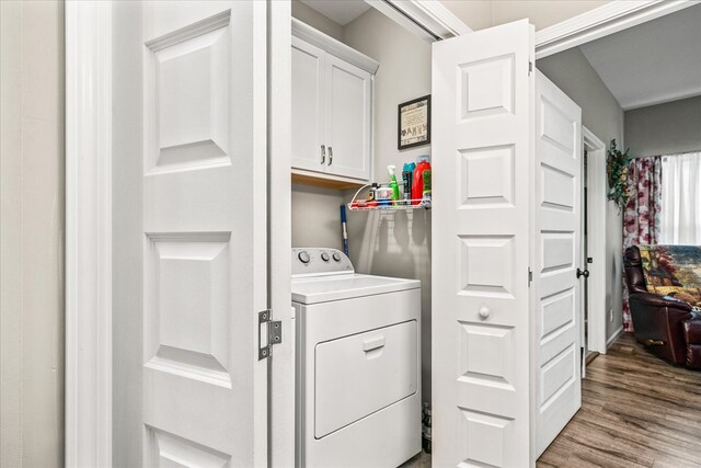 laundry room with washer / clothes dryer, wood finished floors, and cabinet space