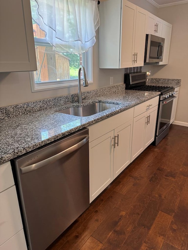 8298 Southfork Rd, Baxter, TN 38544 - kitchen featuring appliances with stainless steel finishes, dark wood-style floors, light stone counters, white cabinets, and ornamental molding