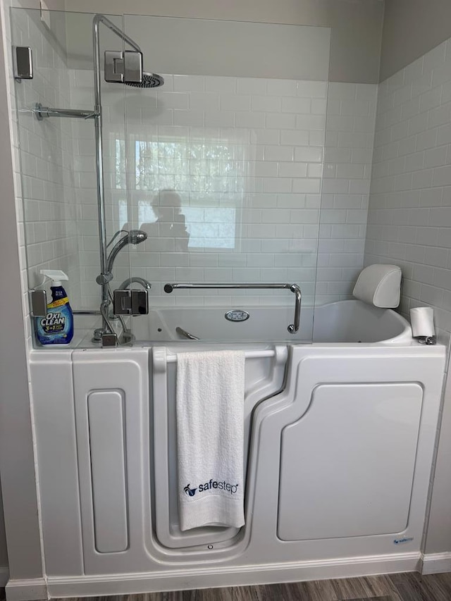 8298 Southfork Rd, Baxter, TN 38544 - bathroom featuring a garden tub, tile walls, and wood finished floors