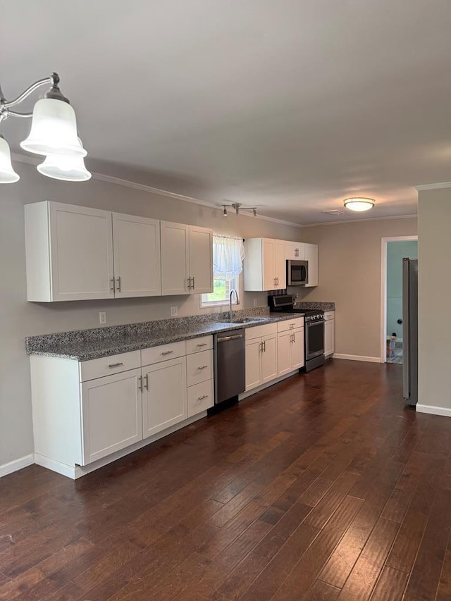 8298 Southfork Rd, Baxter, TN 38544 - kitchen with stainless steel appliances, white cabinetry, dark wood finished floors, crown molding, and track lighting