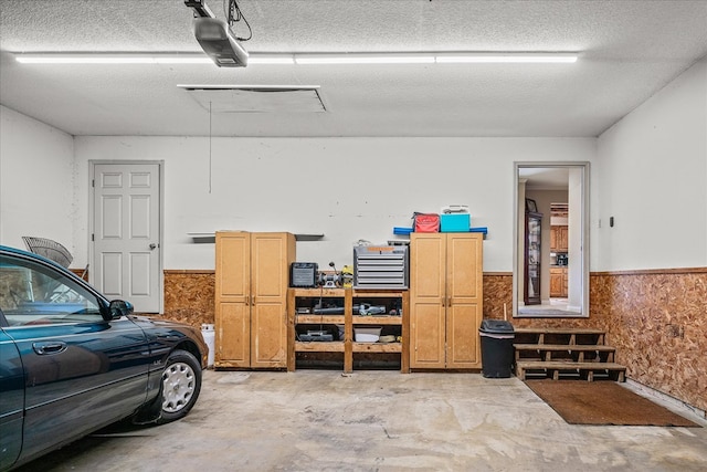 garage with a garage door opener and wainscoting