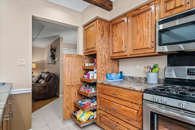 kitchen with appliances with stainless steel finishes, brown cabinets, crown molding, and light tile patterned flooring