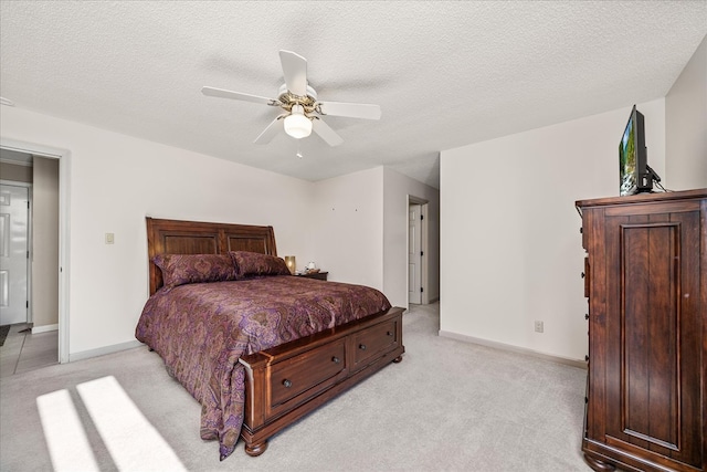 bedroom with light carpet, a ceiling fan, baseboards, and a textured ceiling