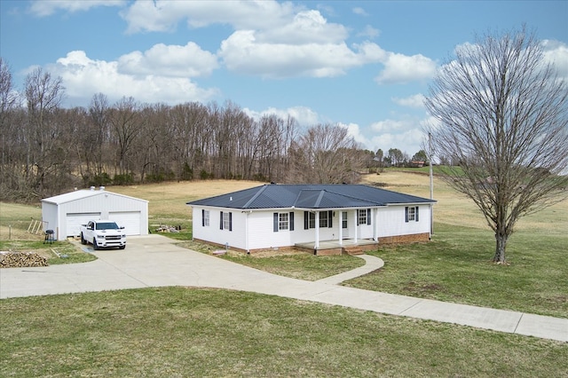 view of front of house with a front yard, covered porch, an outdoor structure, a detached garage, and metal roof