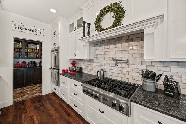 8275 Medlin Rd, Baxter, TN 38544 - kitchen with appliances with stainless steel finishes, white cabinetry, decorative backsplash, dark wood-style flooring, and recessed lighting