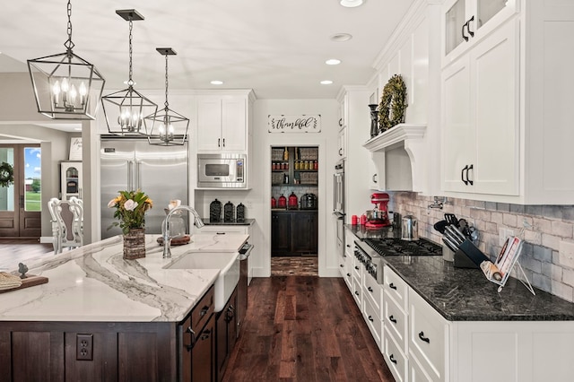 8275 Medlin Rd, Baxter, TN 38544 - kitchen with built in appliances, white cabinetry, a chandelier, backsplash, and dark wood-type flooring