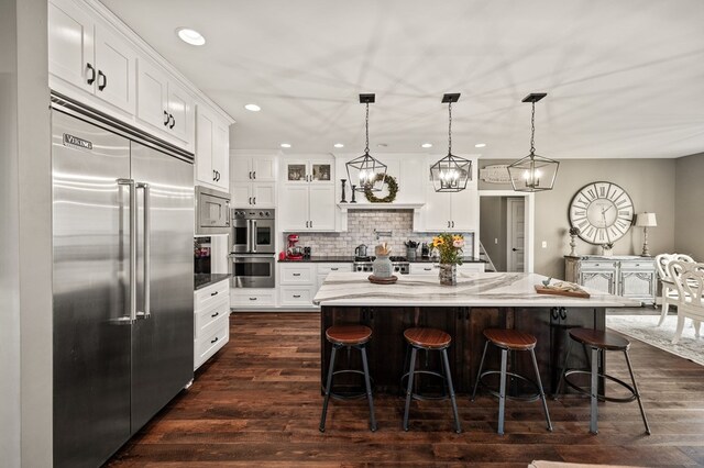 8275 Medlin Rd, Baxter, TN 38544 - kitchen with built in appliances, recessed lighting, decorative backsplash, white cabinetry, and a kitchen breakfast bar