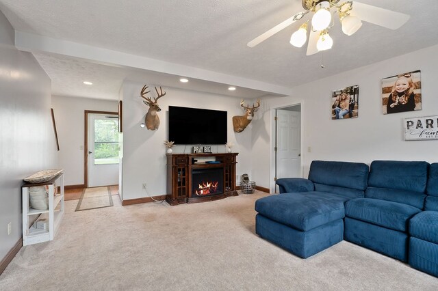 1841 SW Jones Chapel Rd, Byrdstown, TN 38549 - living area featuring light colored carpet, baseboards, recessed lighting, a textured ceiling, and a warm lit fireplace