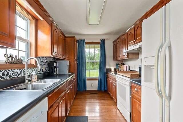 1841 SW Jones Chapel Rd, Byrdstown, TN 38549 - kitchen featuring white appliances, under cabinet range hood, a sink, light wood finished floors, and brown cabinets