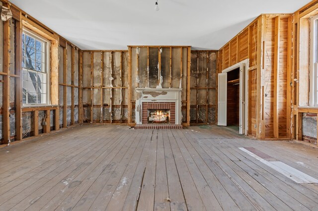 unfurnished living room featuring a brick fireplace and light wood-style floors