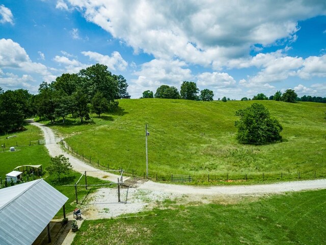 surrounding community with a rural view, fence, and volleyball court