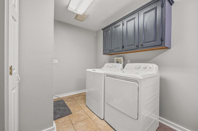 washroom with light tile patterned flooring, washing machine and dryer, visible vents, baseboards, and cabinet space