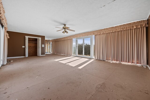 empty room with ceiling fan and a textured ceiling